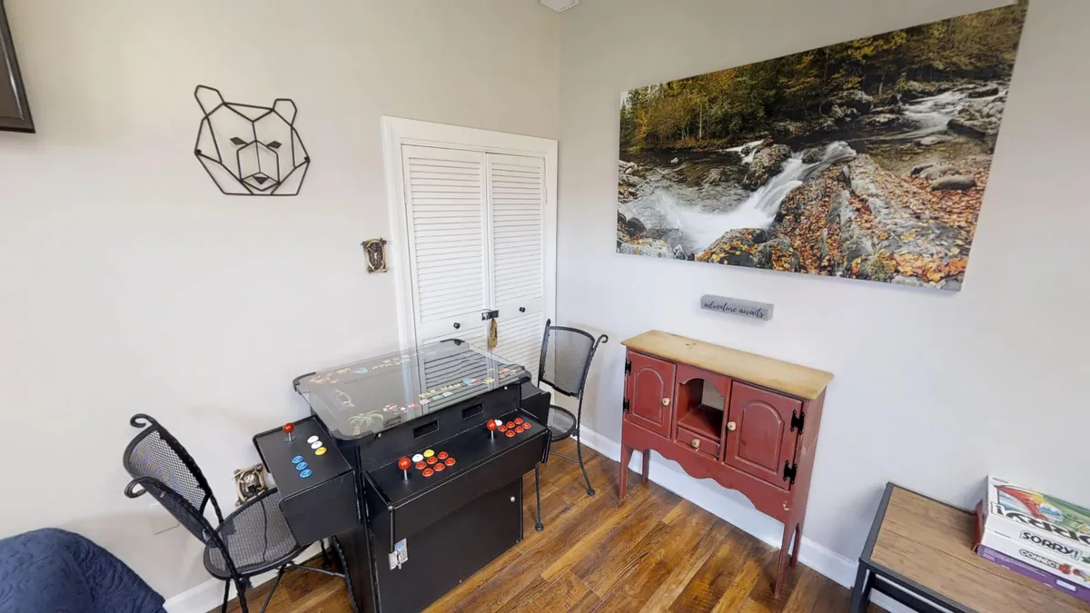 A lively nook featuring a classic arcade game table, colorful wall art, and a distinctive red cabinet. The playful ambiance invites guests to gather for games and shared laughter, perfectly capturing the energy of a fun loft retreat.